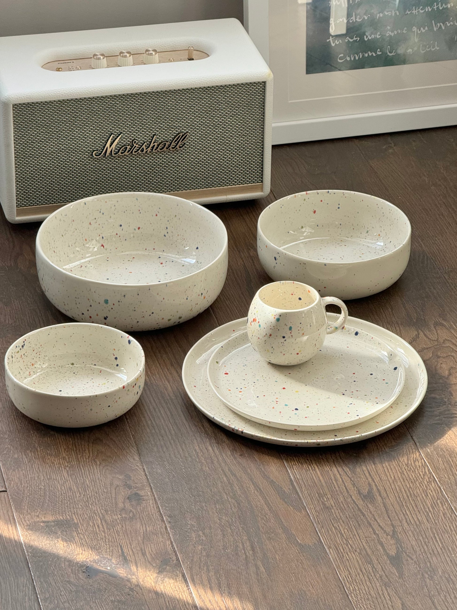 Cozy modern tableware aesthetic featuring Egg Back Home colorful splatter ceramic bowls and plates.
